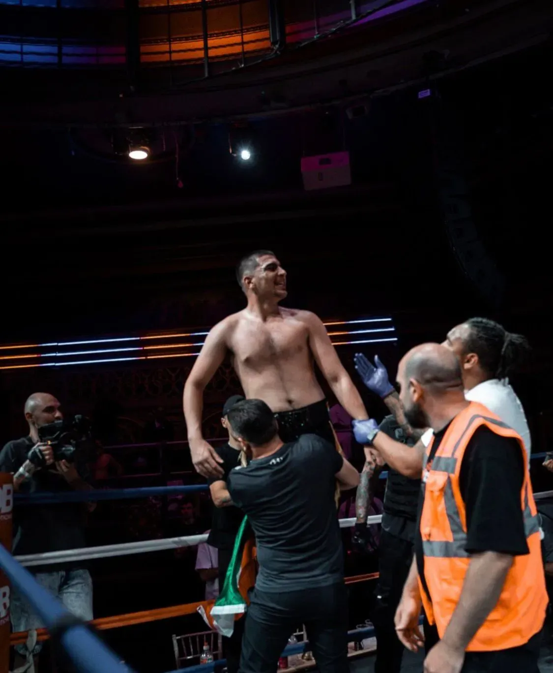 Boxer with hands raised in victory inside the ring